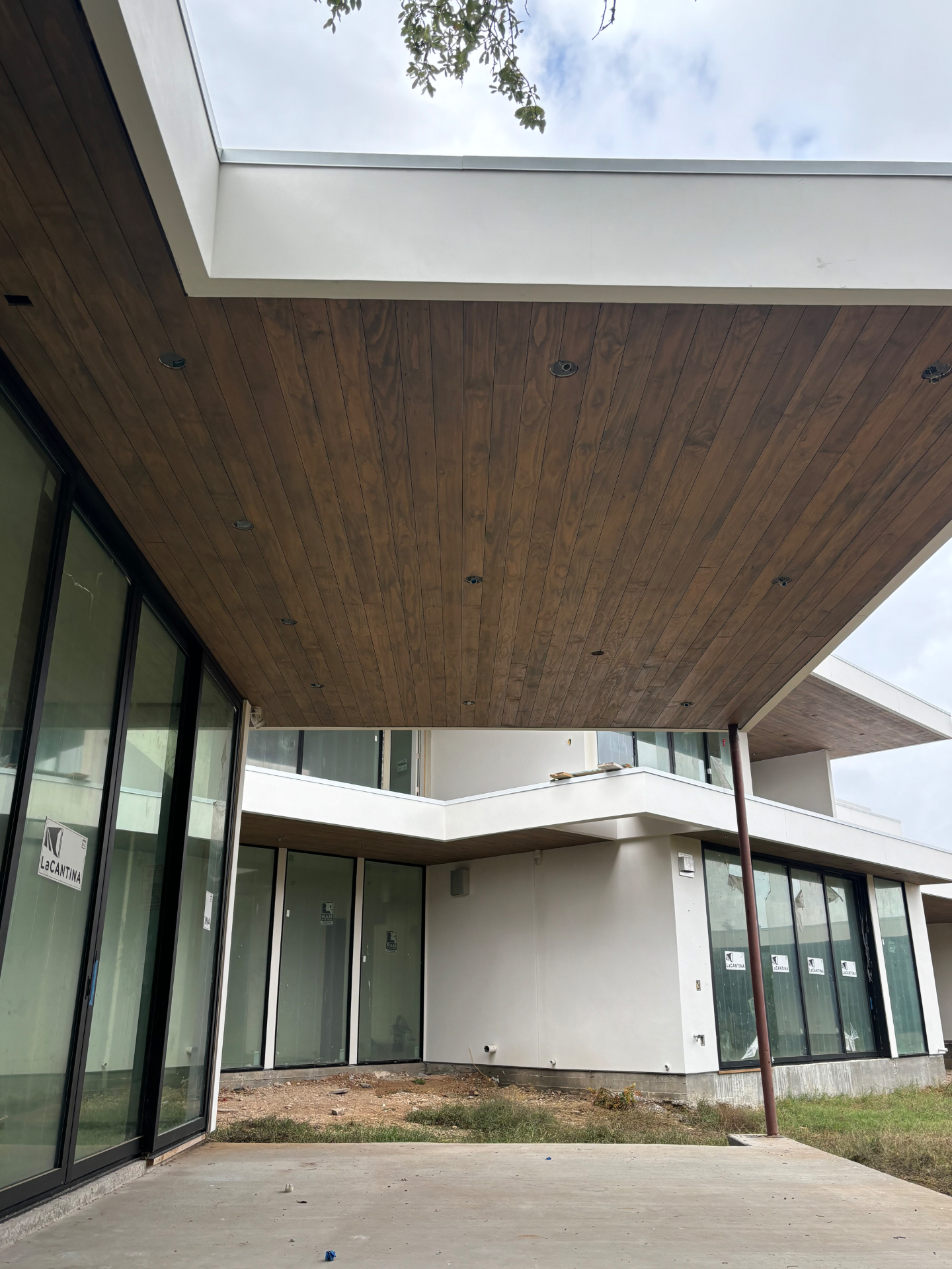 Stained wood soffit ceilings on a modern white custom home under construction
