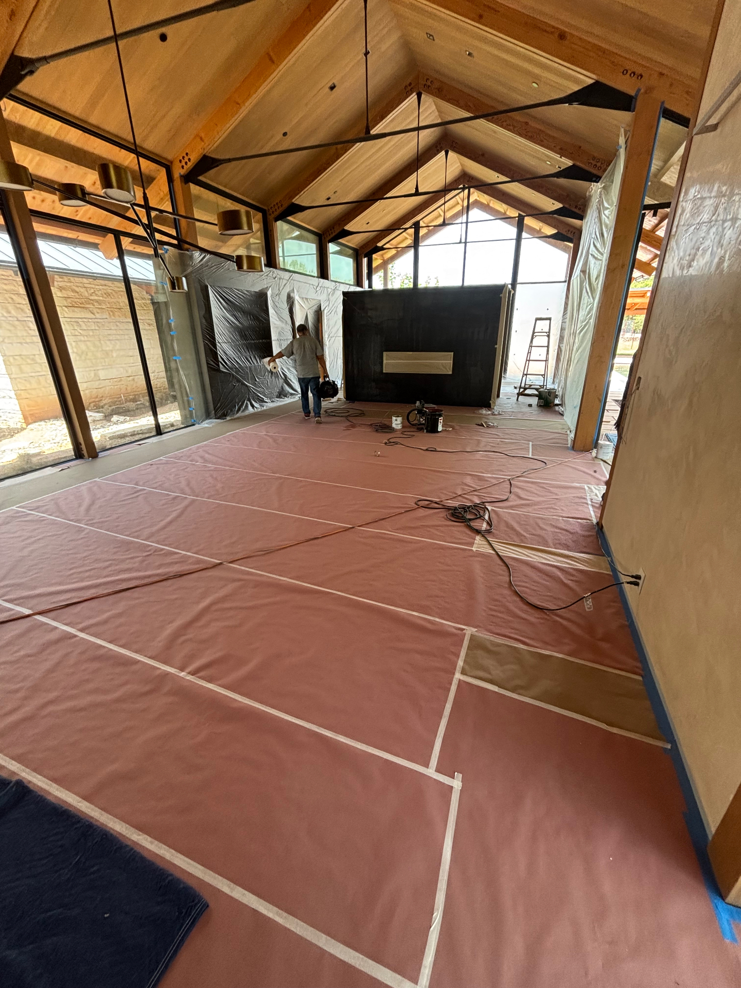 Custom home interior with floors and windows fully covered before painting