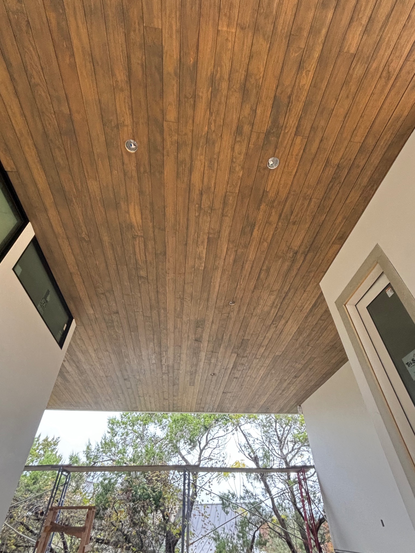 Warm stained wood plank ceiling over a covered patio