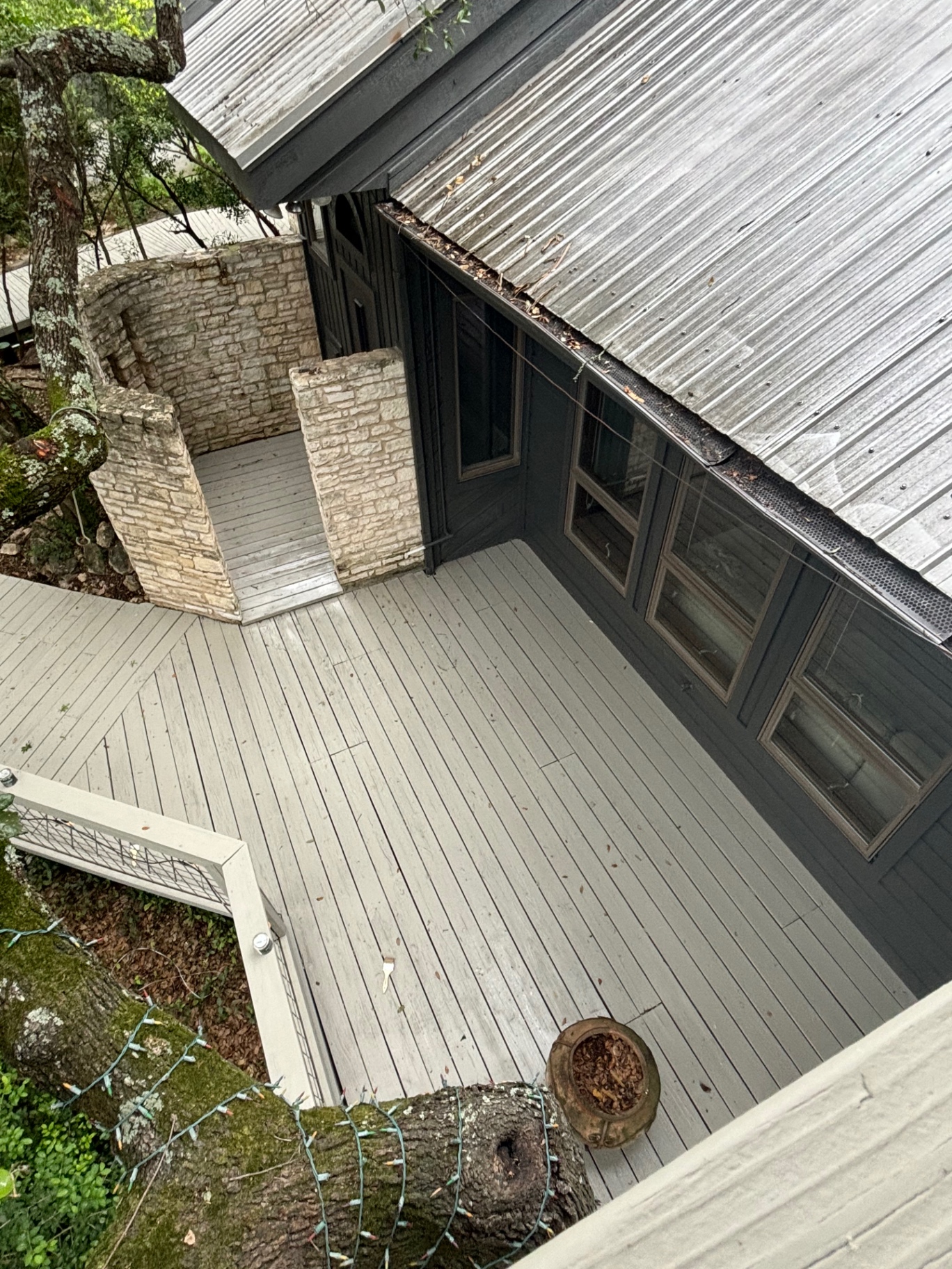 Aerial view of a multi-level painted deck beside a dark-sided home