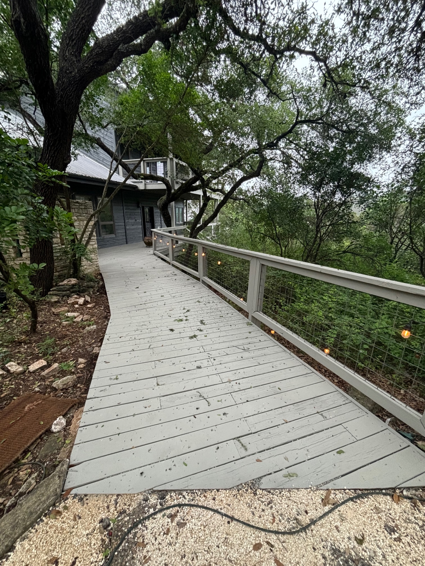 Gray painted deck walkway with matching railings winding through the trees