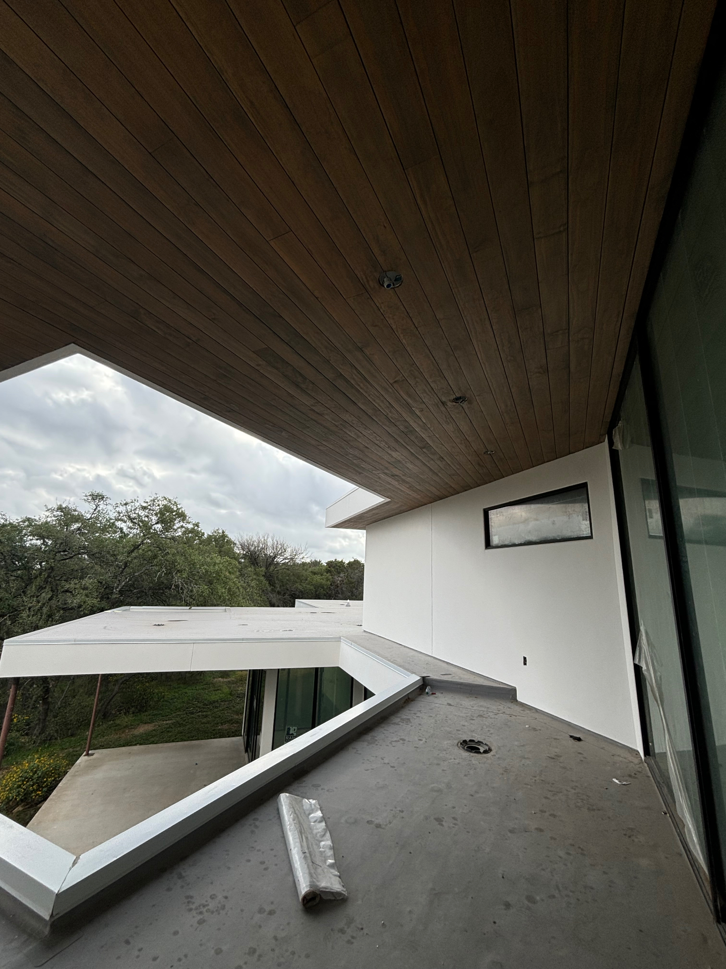 Dark stained wood soffit above a rooftop patio with hill country views
