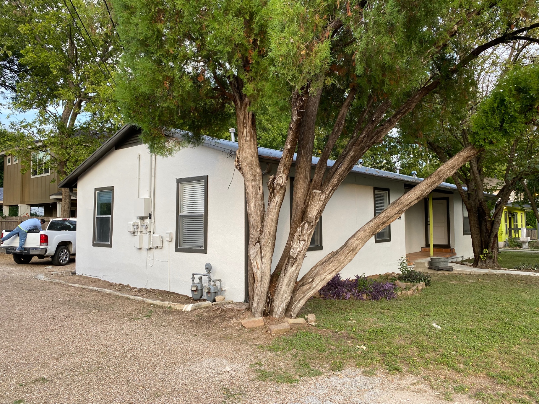 Cream stucco bungalow with dark window trim freshly painted